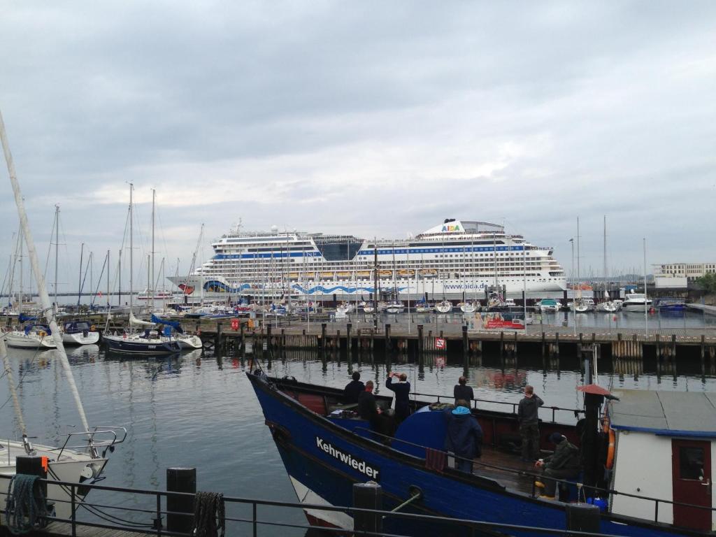 a boat docked at a dock with a cruise ship at Exclusive FEWO in Warnemünde, 150m to the beach, 2 bathrooms, 2 bedrooms, sauna, WiFi and much more. in Rostock