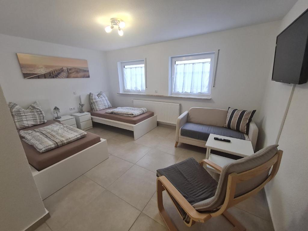 ein Wohnzimmer mit einem Sofa und einem Stuhl in der Unterkunft Schöne helle Wohnung in Malsch in Malsch