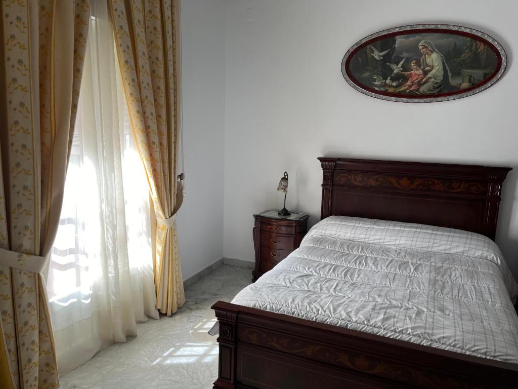sypialnia z łóżkiem i zdjęciem na ścianie w obiekcie Pino Grande 16 w mieście El Viso del Alcor