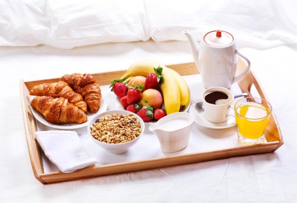 a tray of breakfast foods and coffee on a bed at Complete Apartment peacefully situated near the Airport Nürnberg in Nürnberg