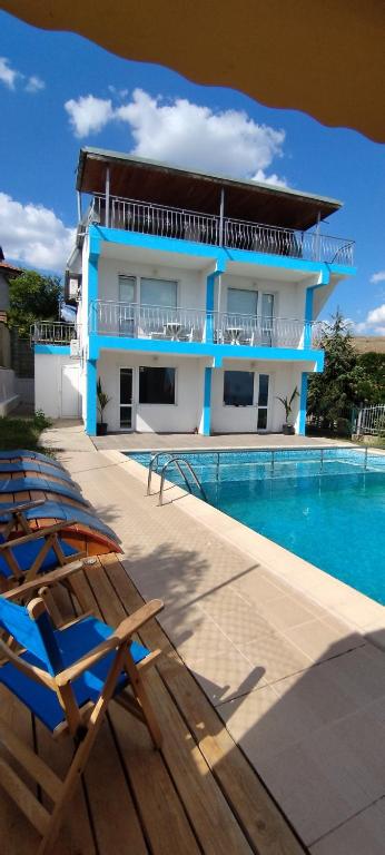 a villa with a swimming pool and a house at Antorino in Balchik