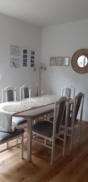 a dining room table with chairs and a table and a mirror at Willa Paulina in Nadole