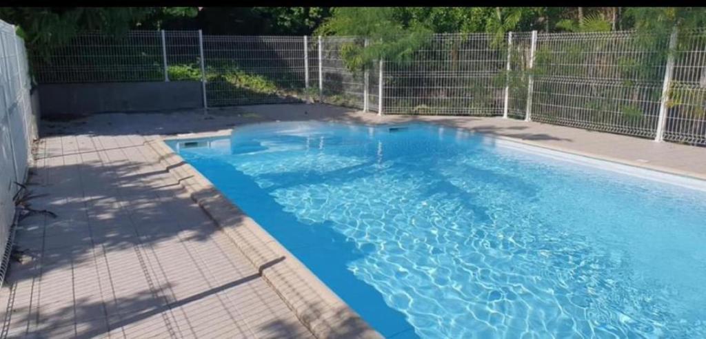 una piscina con agua azul en un patio trasero en Freda, en Marigot