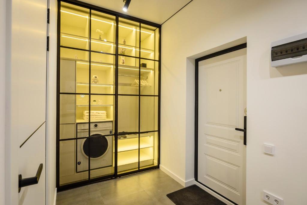 um closet com uma porta de vidro em Пять НОВЫХ апартаментов БИЗНЕС КЛАССА в ЖК R-HOUSE в 100 м от MEGA em Almaty