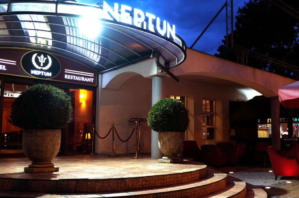 加茨比亞格拉的住宿－Neptun Ψ，楼前有两株植物的餐厅