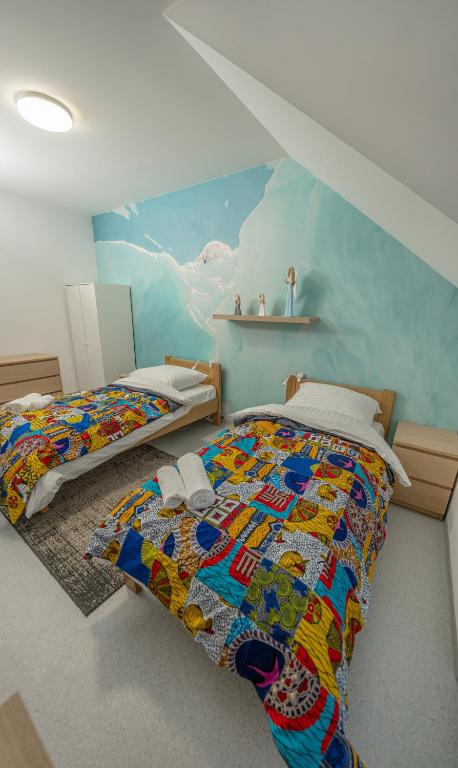 a bedroom with two beds and a painting on the wall at Soul Poznan Free Parking in Poznań
