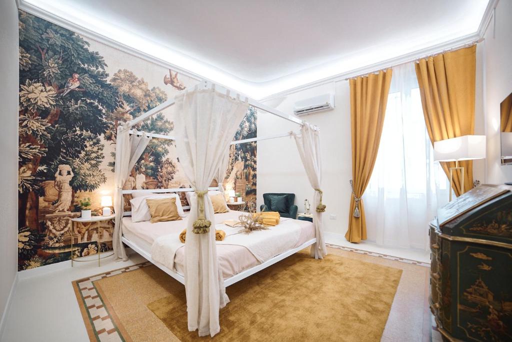 - une chambre avec un lit à baldaquin et une fresque murale dans l'établissement OKRA Apartment Pescara Centro, à Pescara