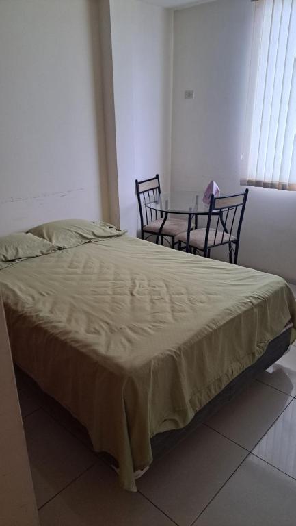 a bed in a room with a table and chairs at Habitación para una persona en Samborondón La Aurora in Estancia Vieja