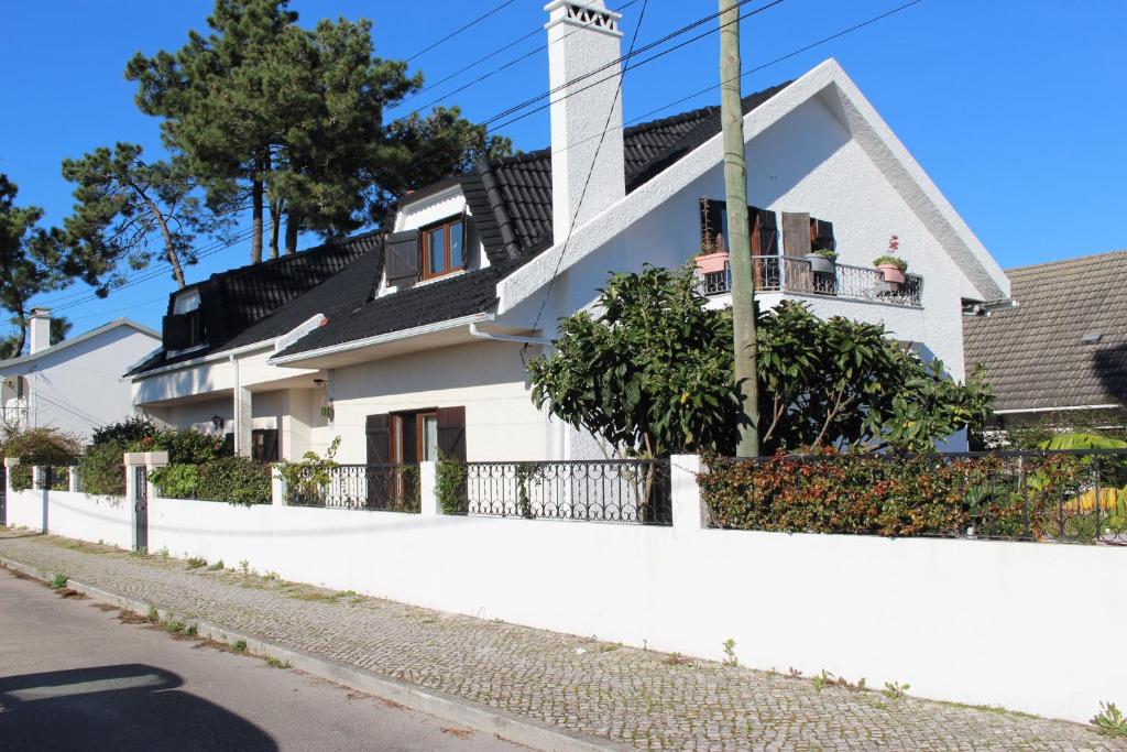 una casa bianca con una recinzione davanti di Bulle Entre Parenthèses a Aroeira