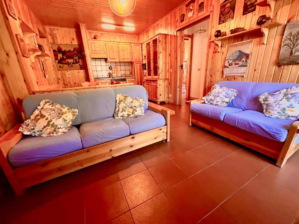 un soggiorno con 2 divani blu in una camera di Dolcevita house in Camigliatello a Camigliatello Silano