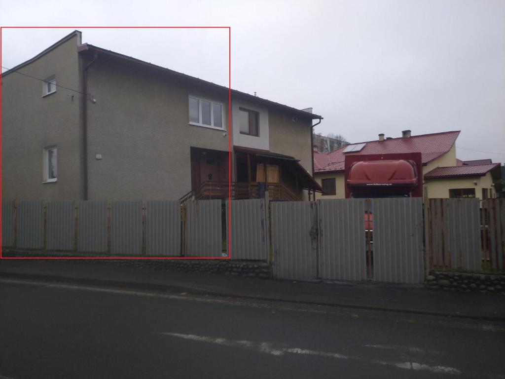 a house with a fence next to a building at Penzión Bardejov pri Nemocnici in Bardejov