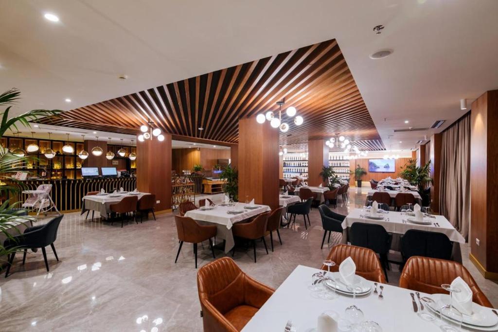 a dining room with tables and chairs in a restaurant at Sunshine Apt Qerret-Golem Beach in Golem