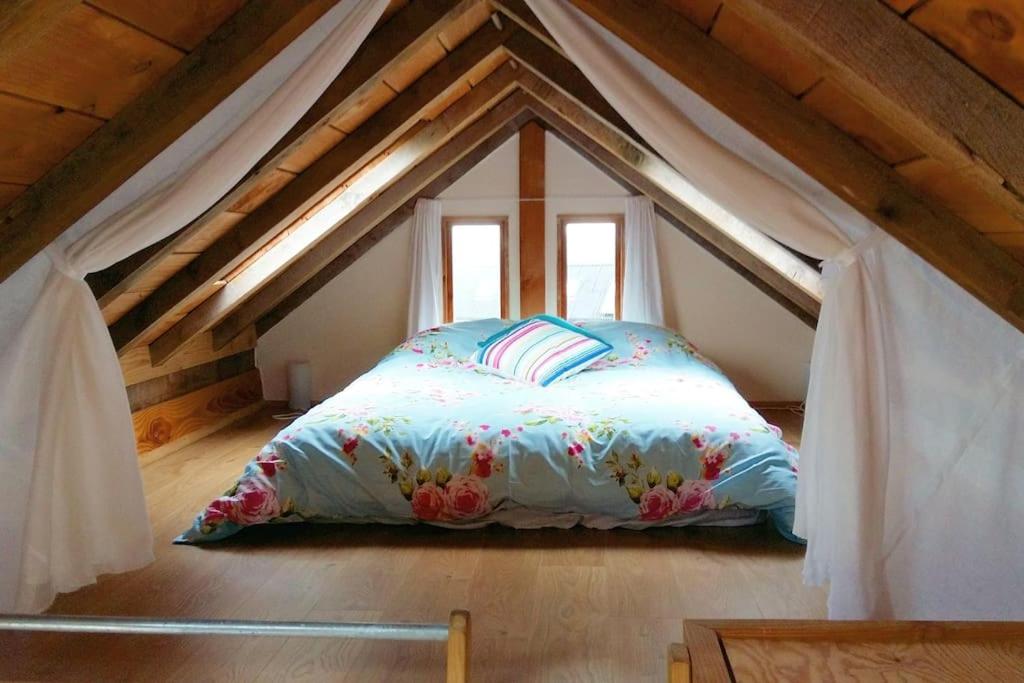a bedroom with a bed in the attic at Log Cabin at The Old Summer Dairy Glastonbury in Somerton