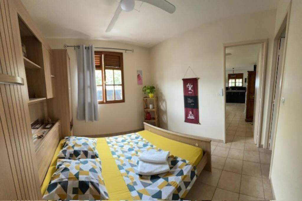 ein Schlafzimmer mit einem gelben und blauen Bett in einem Zimmer in der Unterkunft Ti Sicriers Carbet in Le Carbet
