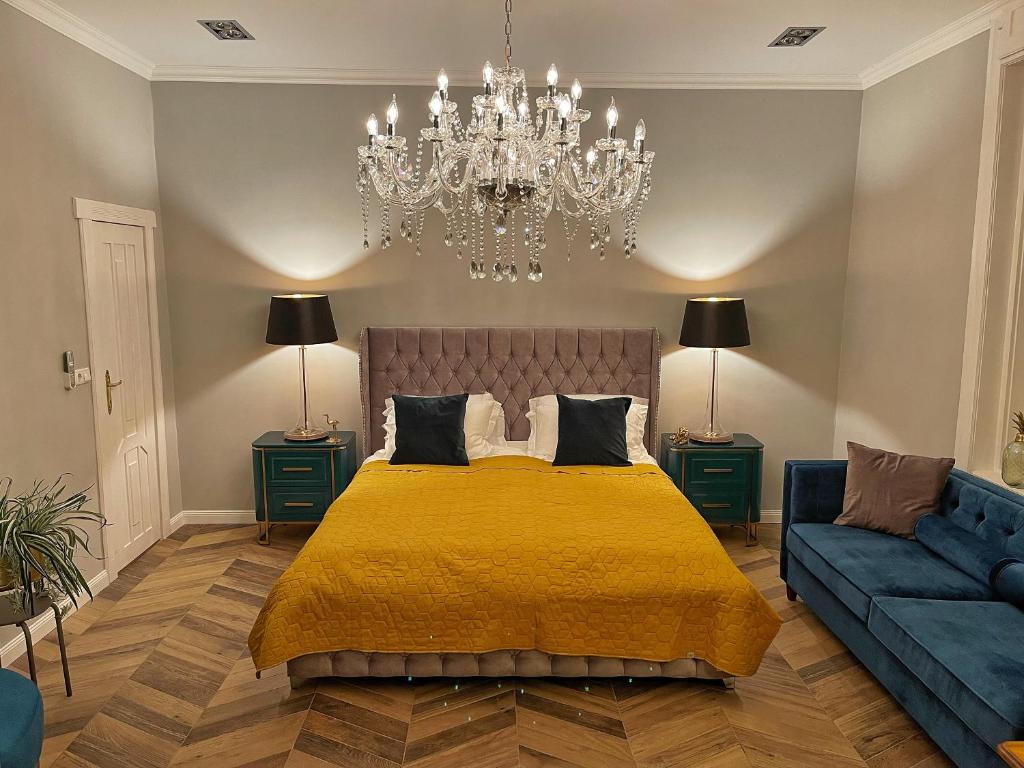 um quarto com uma cama, um candelabro e um sofá em Keszthely Balaton Luxury Villa em Keszthely