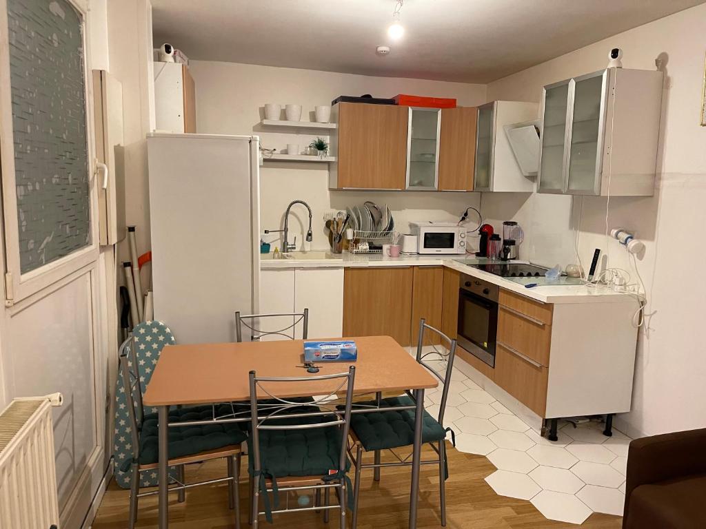 a small kitchen with a table and chairs in it at chambre double std in Longjumeau