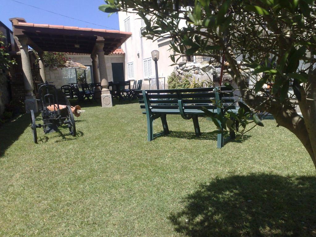 a park bench with a dog laying on the grass at Room solo - Villa Ribeiro On Way to Santiago with Secure Bike Garage - Esposende in Esposende