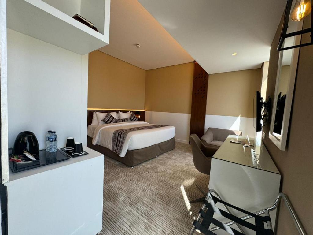 Habitación de hotel con cama y escritorio en Awfad Hotel en Riad