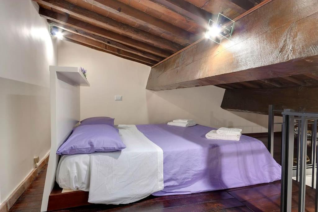 1 dormitorio con 1 cama con sábanas moradas en Verdi - Ampio Monolocale in Santa Croce, en Florencia