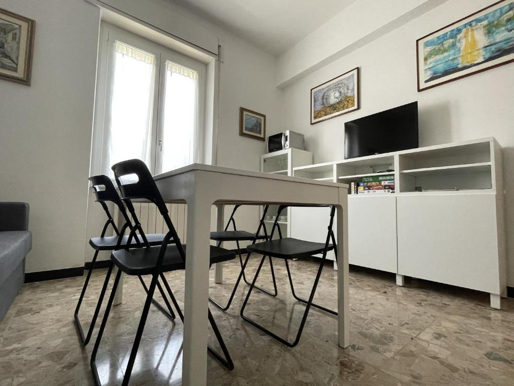 - un salon avec une table et trois chaises dans l'établissement HOST IN LEVANTO - Scirocco con biciclette, à Levanto