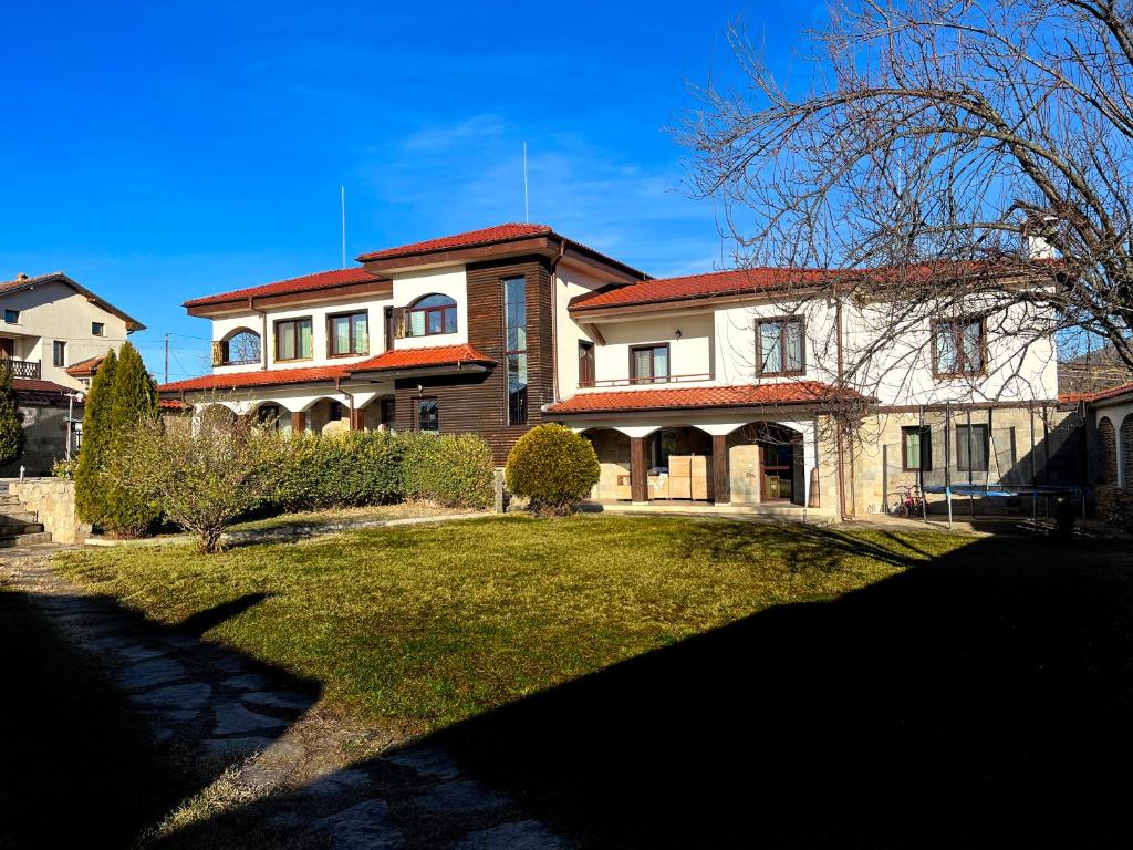 a large house with a grass yard in front of it at Entheos in Vŭrben