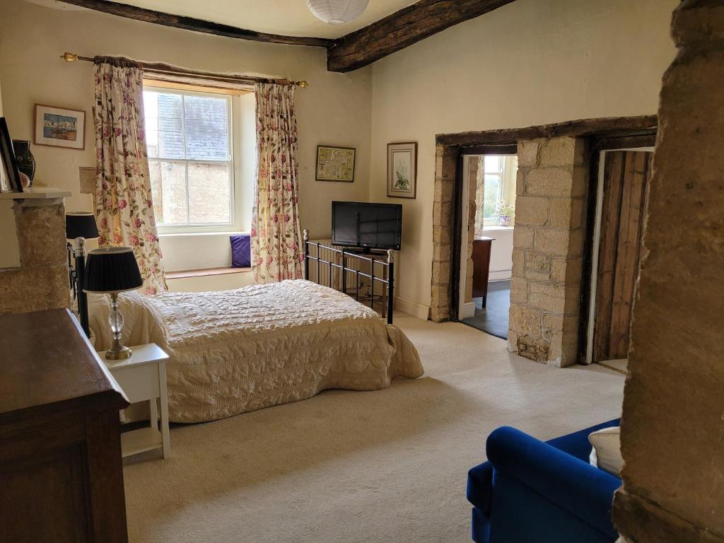 a bedroom with a bed and a tv in it at Prebendal Manor in Nassington