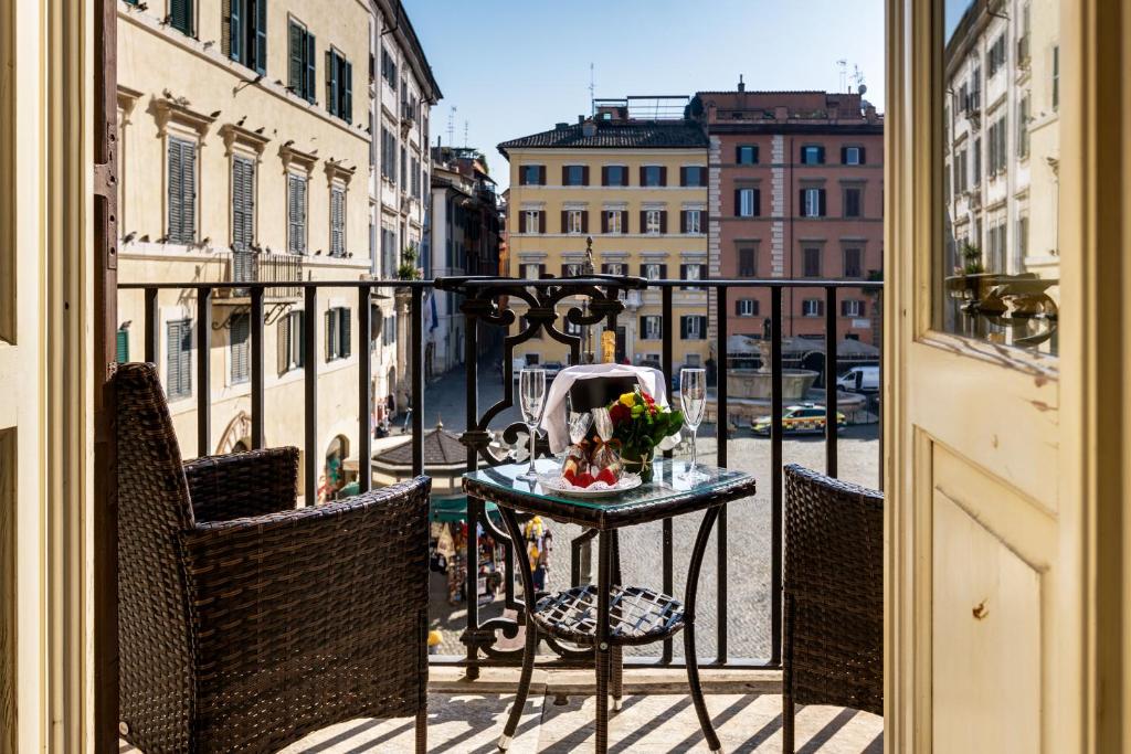 a table on a balcony with a view of a street at Piazza Farnese Luxury Suites in Rome