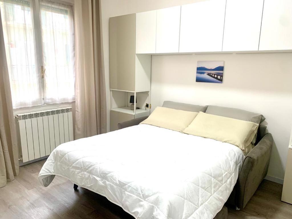 1 dormitorio con 1 cama blanca y armarios blancos en d.s house mare & sentieri, en Rapallo