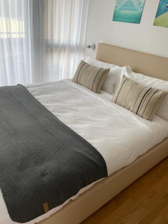 a large white bed in a room with a window at Eh!Toi Self Motel in Etoy