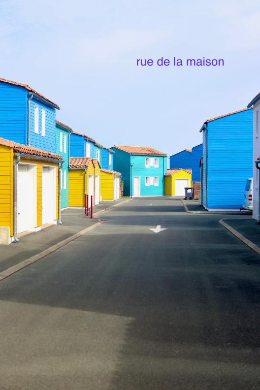 une rue avec des maisons colorées sur le côté d'une route dans l'établissement Près des claires, au Château-dʼOléron