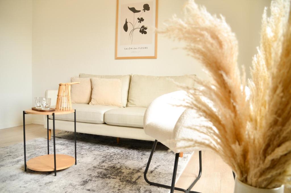 a living room with a couch and a table at MILPAU Bottrop 2 - Modernes und zentrales Premium-Apartment für 4 Personen mit Queensize-Bett und Einzelbetten - Netflix, Nespresso und Smart-TV in Bottrop