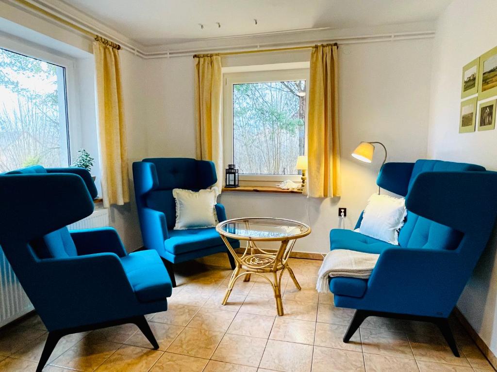 a living room with blue chairs and a table at Agroturystyka Dom Wśród Sosen in Rzędkowice