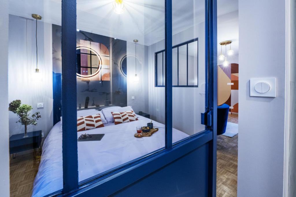 een kamer met een bed en een spiegel bij Wisteria Villa in Écully