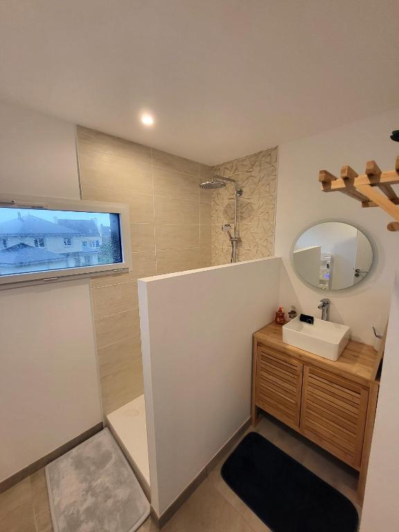 a bathroom with a sink and a mirror at TY COAT - Maison neuve avec vue mer, piscine et bain nordique in Saint-Pabu