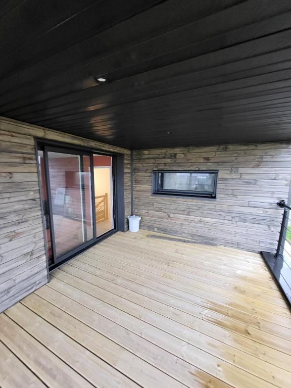a room with a wooden floor and a window at TY COAT - Maison neuve avec vue mer, piscine et bain nordique in Saint-Pabu