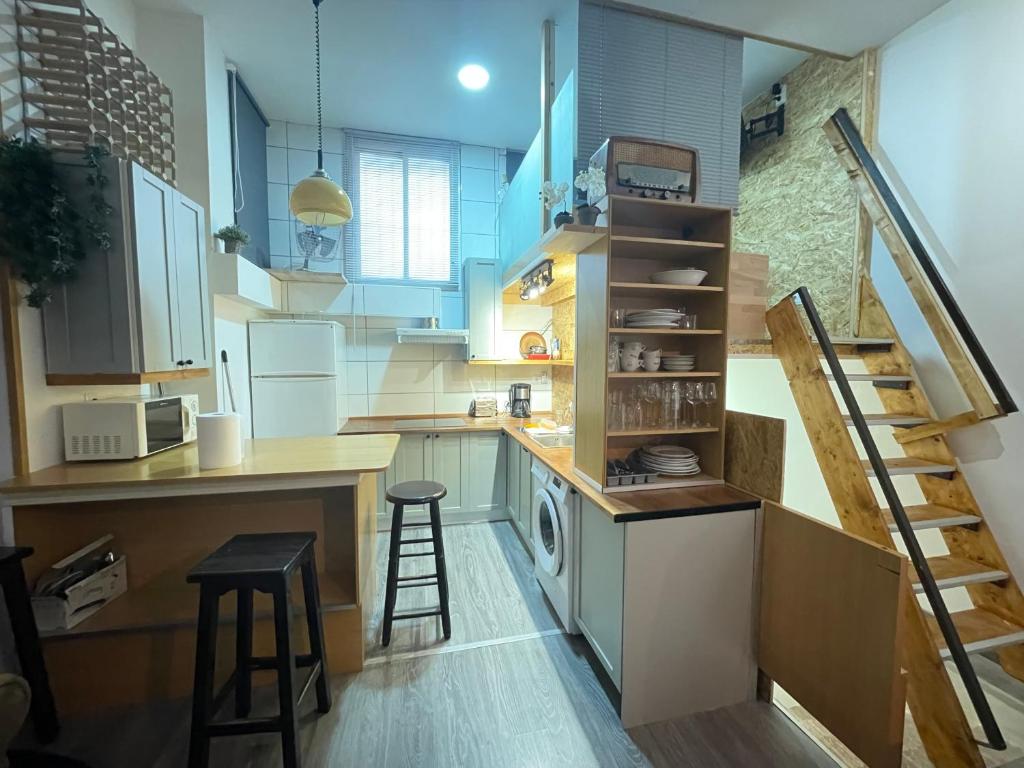 a small kitchen with a staircase and a kitchen with a stove at Luminoso y acogedor bajo en Tetuán by beBalmy in Madrid
