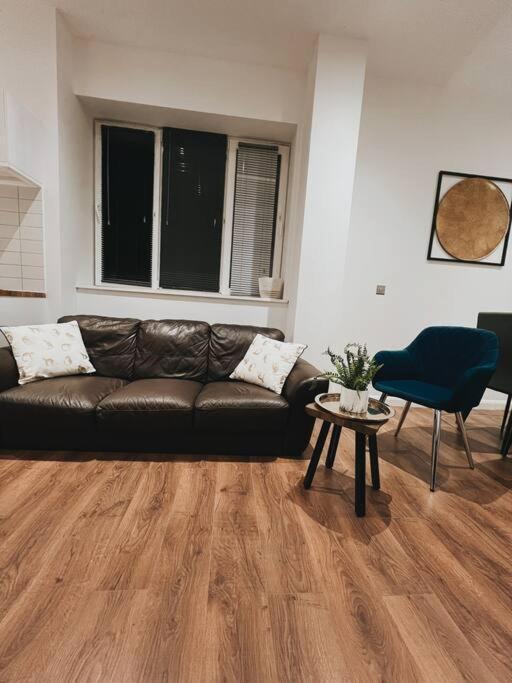 a living room with a leather couch and a table at CentralGem Retreat 02 in Redditch