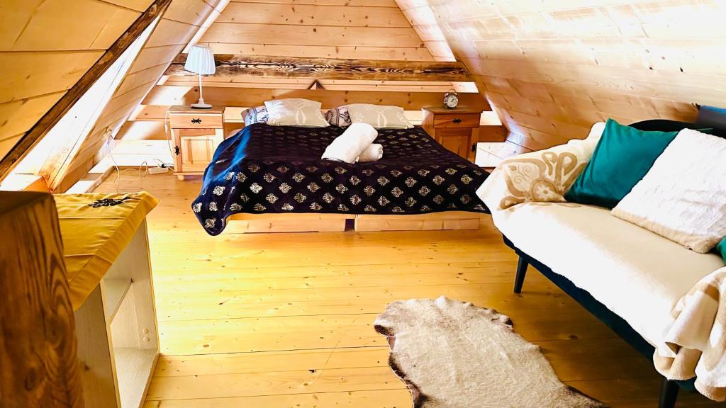 1 dormitorio con 1 cama y 1 sofá en una cabaña en Apartament FOLK en Zakopane
