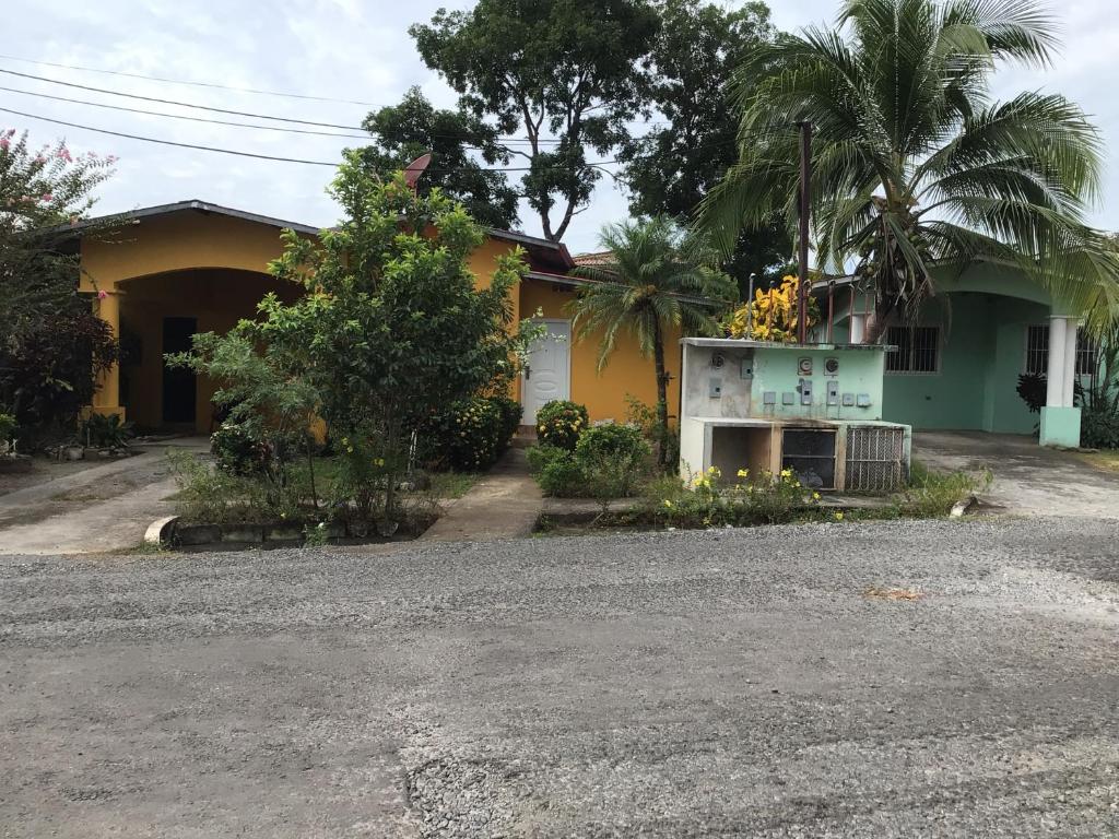une maison jaune et verte avec des palmiers dans l'établissement Urbano y comodo, à David
