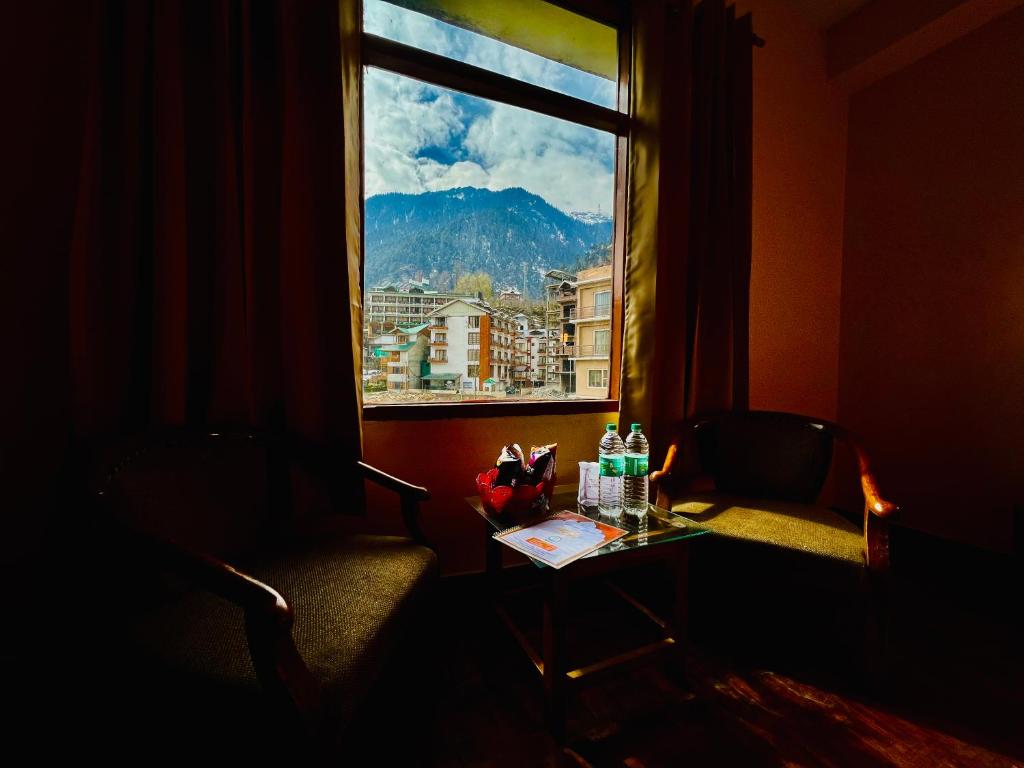 een kamer met een tafel en een raam met uitzicht bij The Kalinga Resort Manali - Heaven In Mountains in Manāli