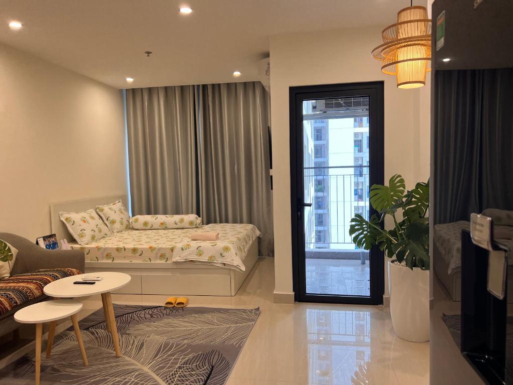 a room with a bed and a table and a couch at Vinhome Grand Park Homestay-Sweet Home Origami in Long Bình