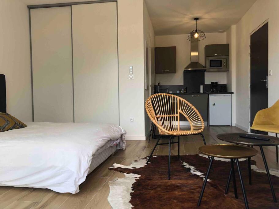 une chambre avec un lit, une table et une chaise dans l'établissement Magnifique Studio dans Résidence neuve, à Corte