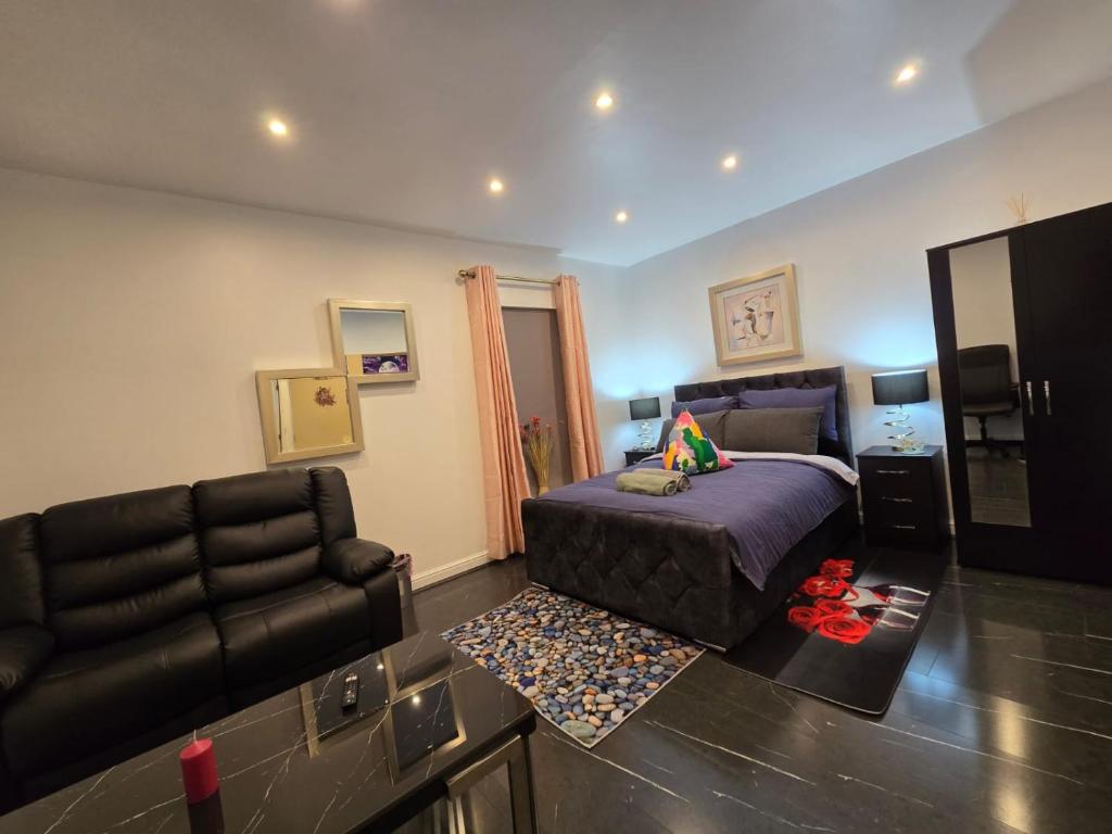 a bedroom with a bed and a couch and a chair at 38 Church Street Luxury Flat in Warrington