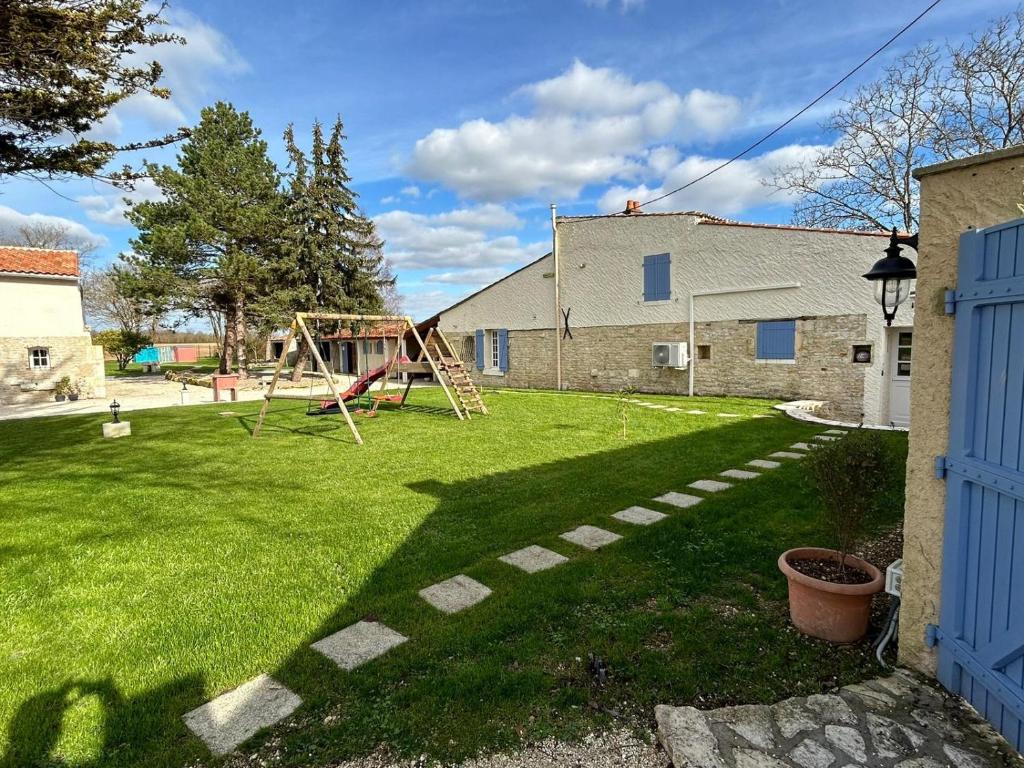 a yard with a swing set in the grass at Gîtes du Fanal 