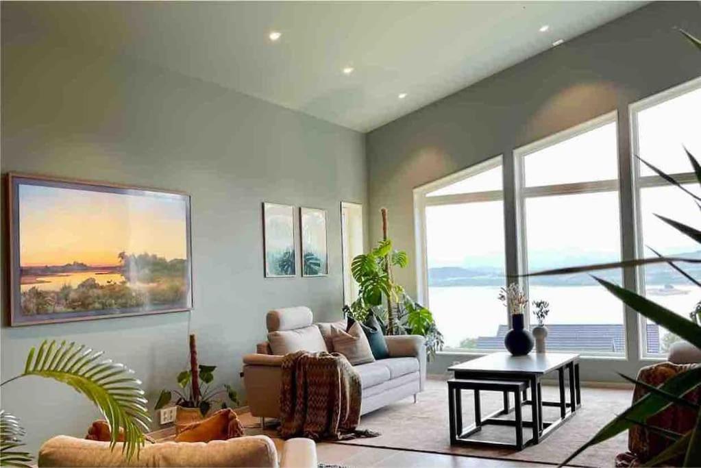 un salon avec un canapé blanc et des plantes dans l'établissement Arctic Villa, à Kvaløya