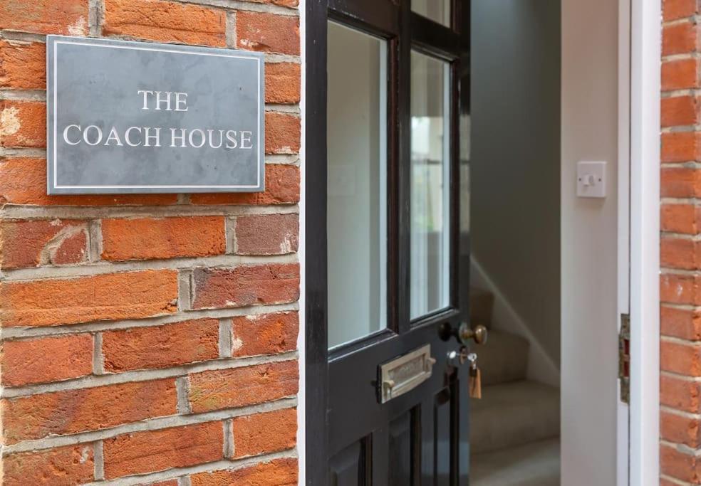 a brick wall with a sign that reads the coach house at Stylish and homely 1 bed Edwardian Coach House in Colchester
