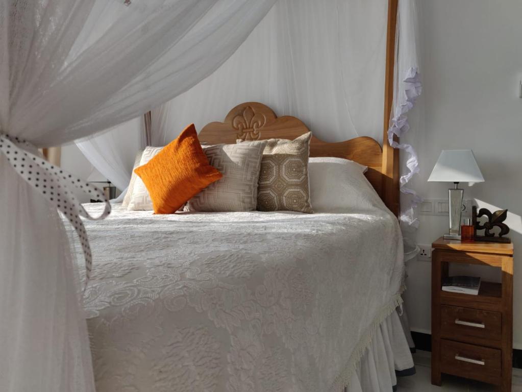 - une chambre avec un lit blanc et des oreillers dans l'établissement Luxury Beach Condo Dehiwala Mt Lavinia, à Watumulla