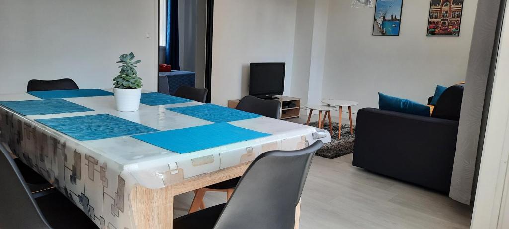 Habitación con mesa con sillas, mesa y mesa. en Appartement Entre terre et mer, en Dunkerque