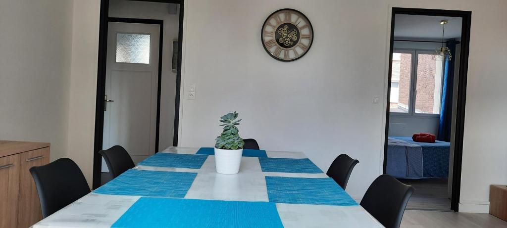 una mesa de comedor con una maceta. en Appartement Entre terre et mer, en Dunkerque