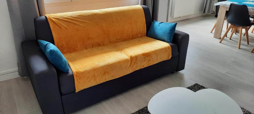 Una silla negra con una manta naranja. en Appartement Entre terre et mer, en Dunkerque